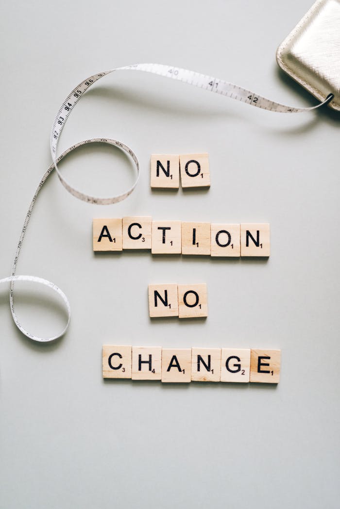 gallery-6 Scrabble tiles form motivational message ‘No Action No Change’ with a measuring tape.